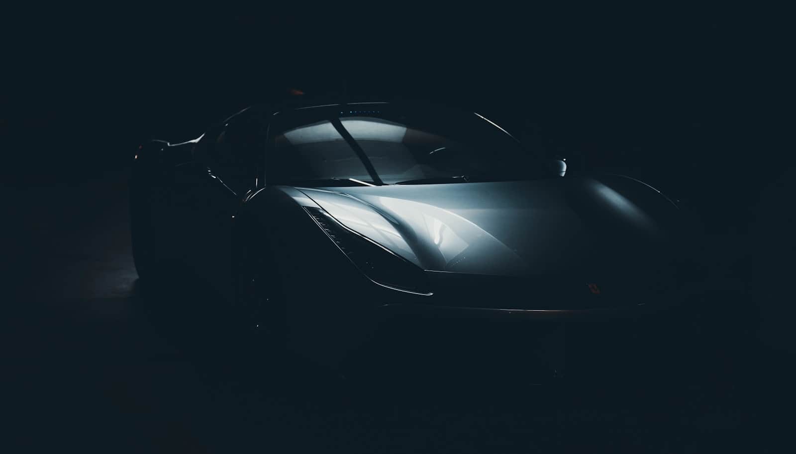 Dark sports car under studio lighting, specular highlights running across corrected paint