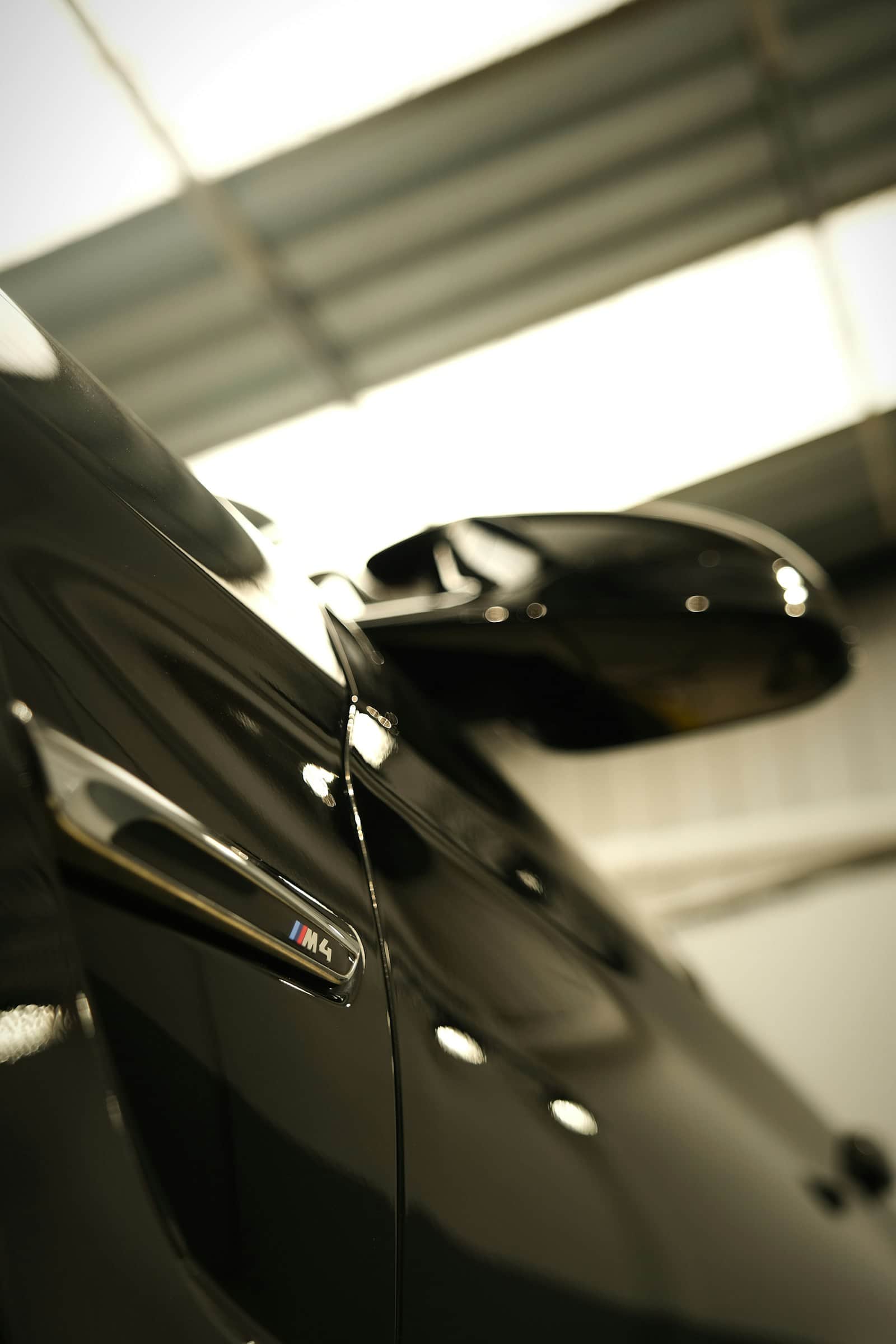 Glossy black M4 fender and mirror under workshop lighting