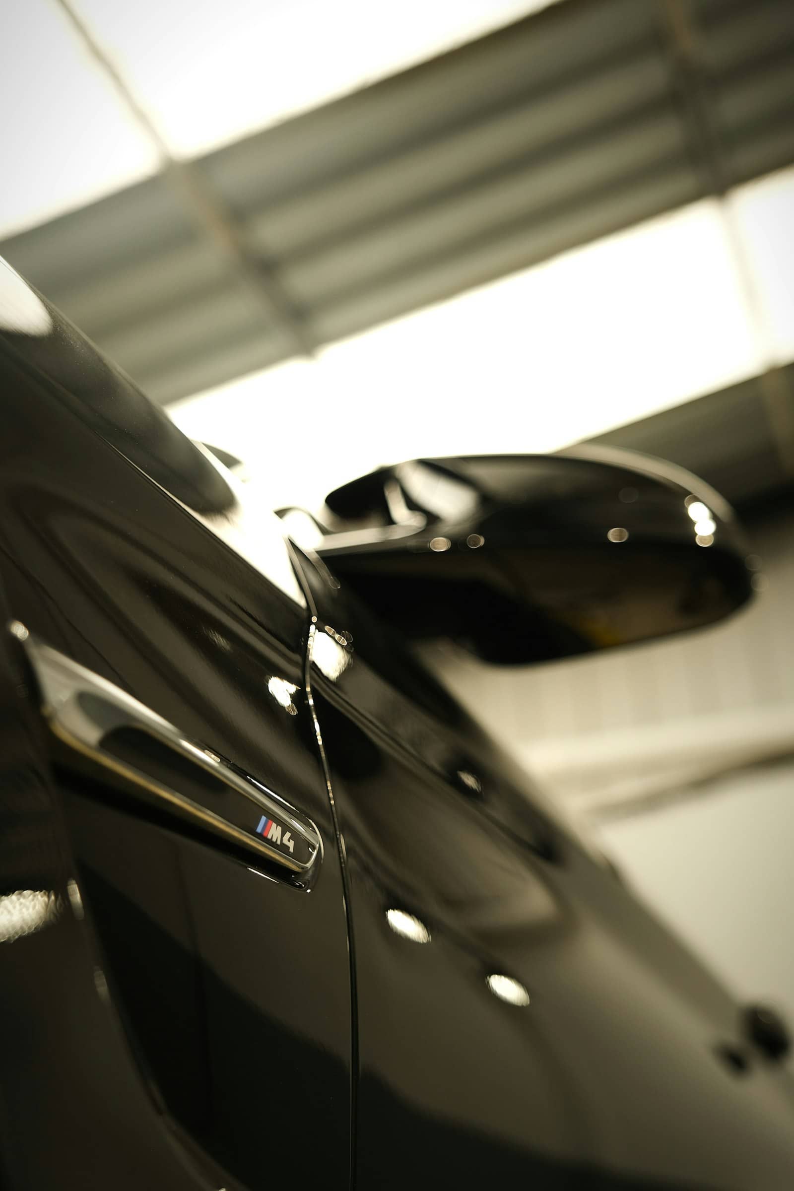 Glossy black M4 fender and mirror under workshop lighting